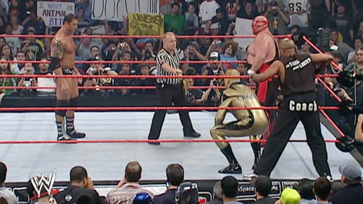 Batista on the left side of the ring with Jonathan Coachman, Goldust and Vader on the right hand side of the ring 