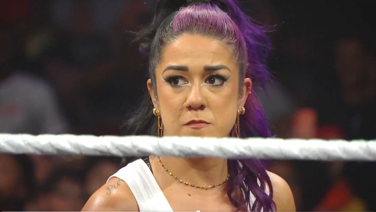 Bayley frowns from the outside of a wrestling ring.