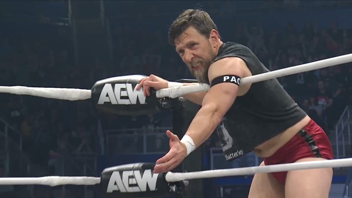 Bryan Danielson on the side of an AEW wrestling ring waits for a tag in a wrestling match.