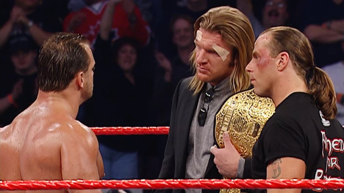 Chris Benoit looking at Triple H and Shawn Michaels, who are both bruised