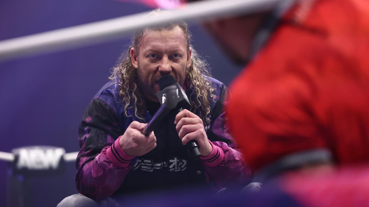 Kenny Omega looking at Will Ospreay on his knees