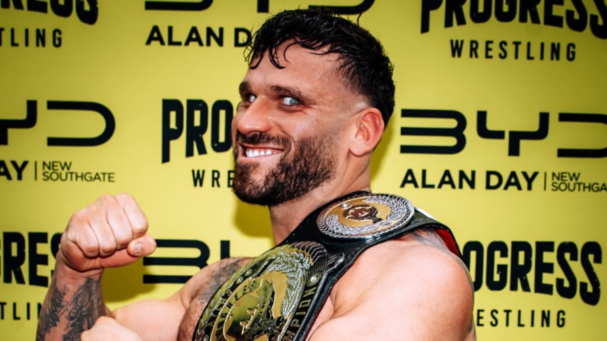 Mike D Vecchio holding the PROGRESS Atlas Title with wild eyes