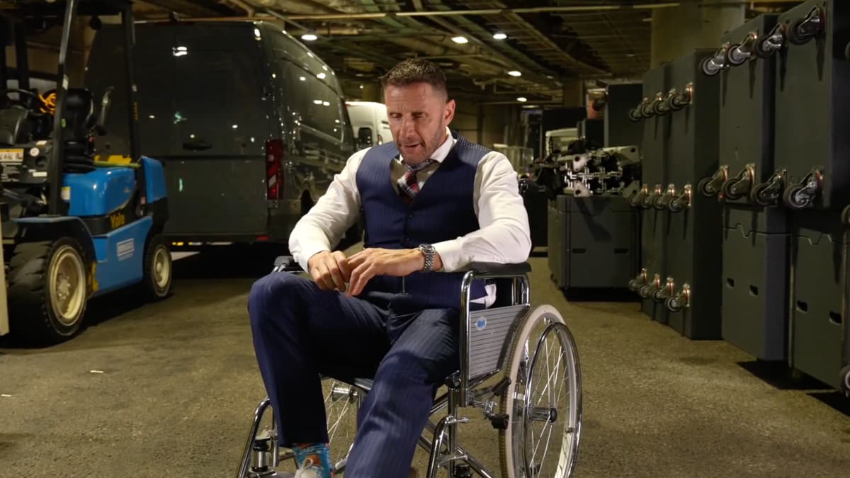 Nigel McGuinness in a suit sitting in a wheelchair