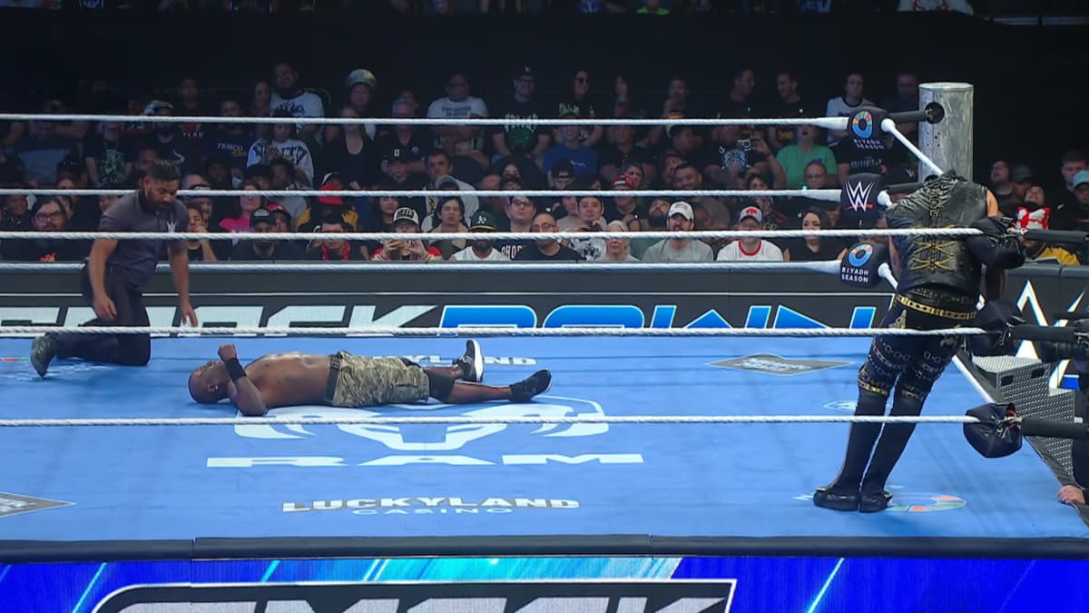 R-Truth lying in the middle of the ring with Damian Priest in the corner