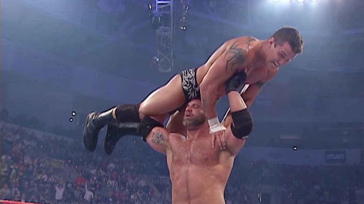 Goldberg with Randy Orton above his shoulders in a Gorilla press