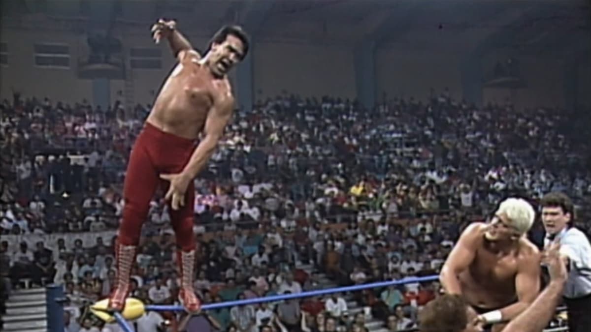 Ricky Steamboat on the apron cheering Dustin Rhodes on