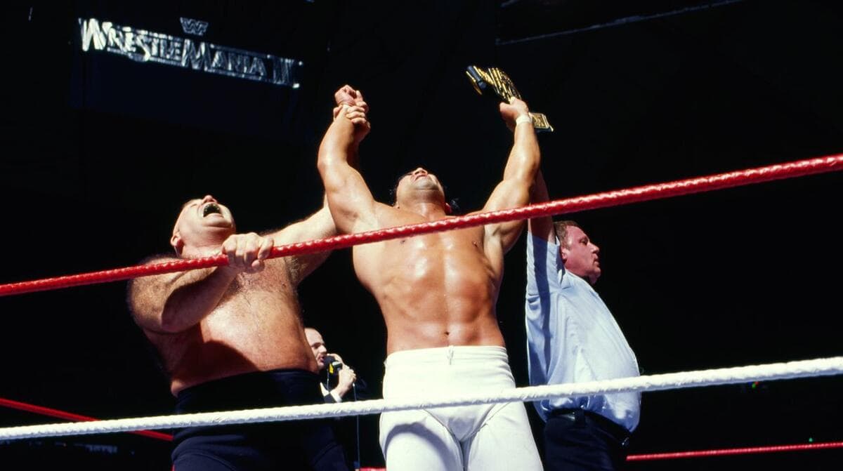 Ricky Steamboat holding up the WWE Intercontinental Title alongside George Steele