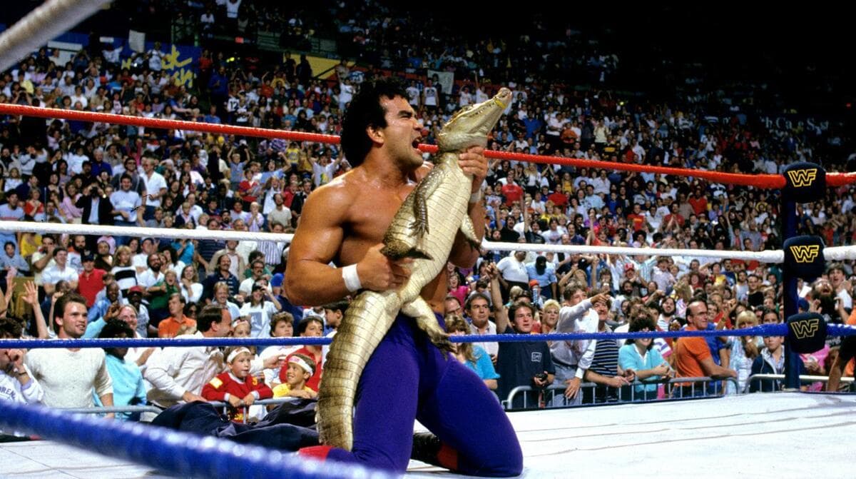 Ricky Steamboat holding a small alligator in a WWE ring