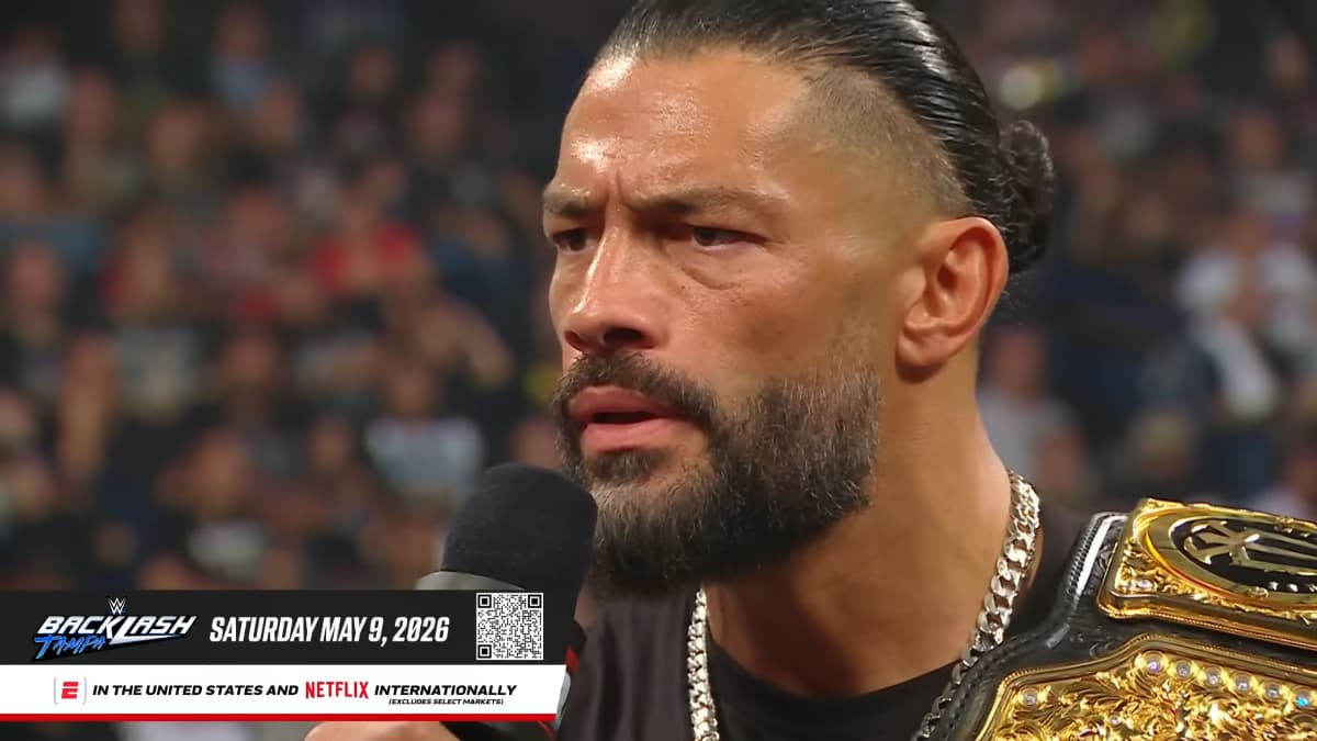 Roman Reigns frowning and holding a microphone in a WWE ring