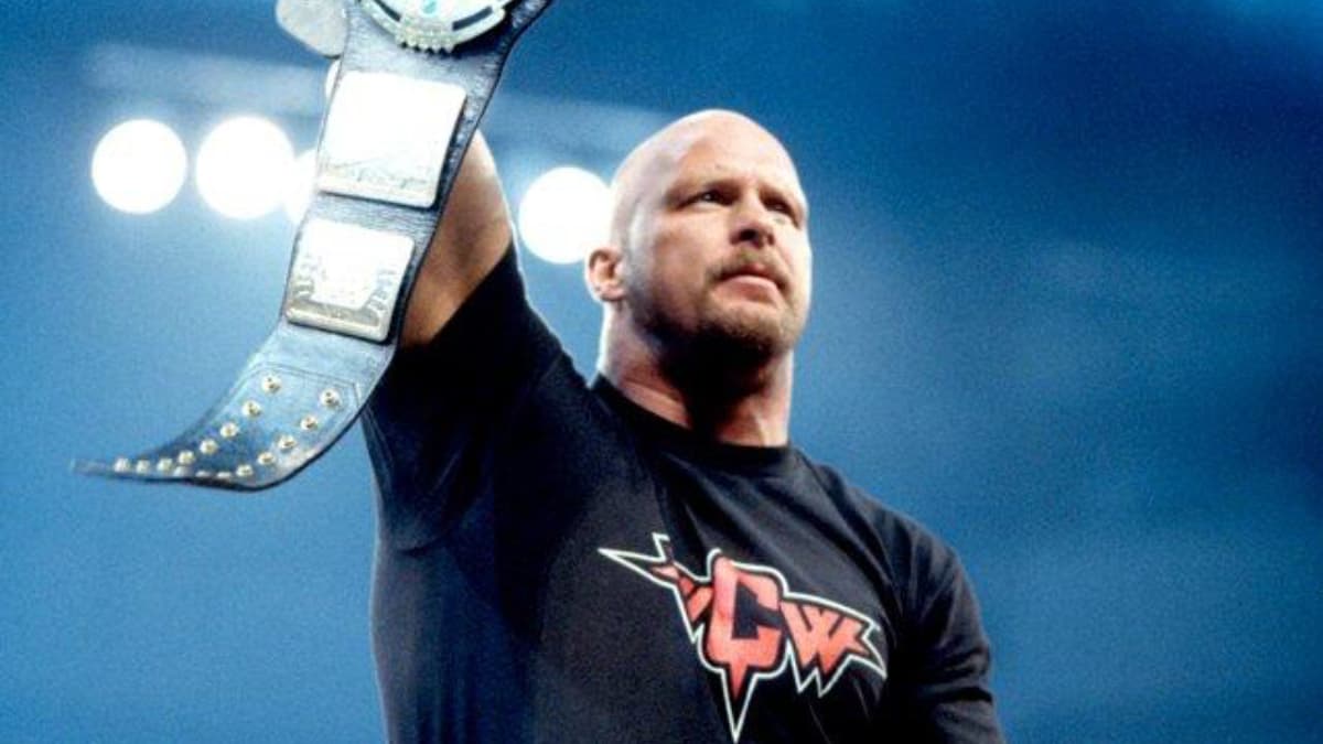 Steve Austin in a WCW t-shirt holding up the WWF Championship
