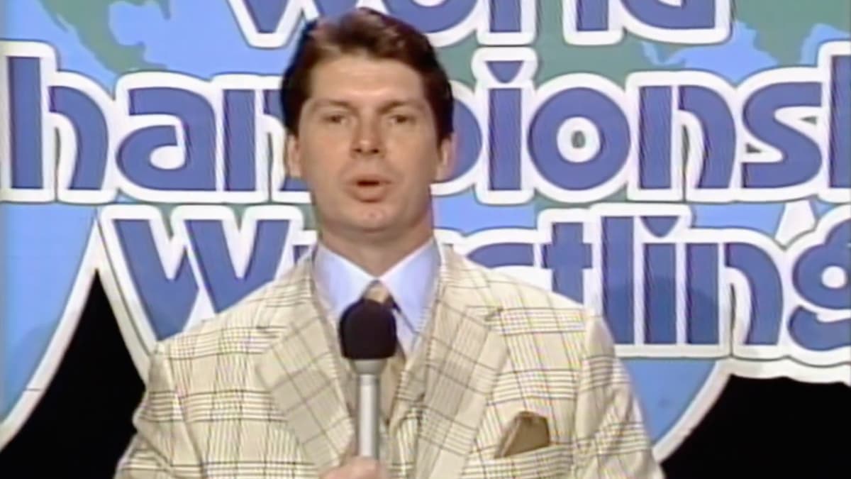 Vince McMahon standing in front of a World Championship Wrestling back drop