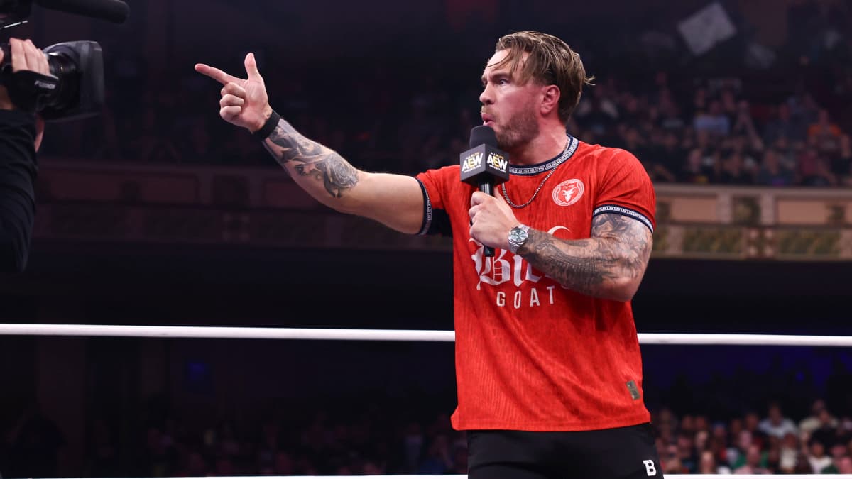 Will Ospreay pointing his finger in a red t-shirt