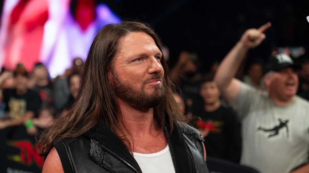AJ Styles smiling while wearing a white vest and leather jacket vest at TNA Slammiversary 2025