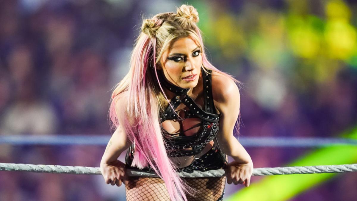 Alexa Bliss leaning on ring ropes in an arena.