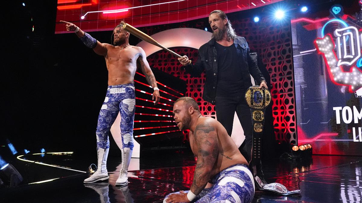 Colten Gunn pointing, Jay White angrily holding a baseball bat and a championship belt, and Austin Gunn sitting on AEW entrance stage