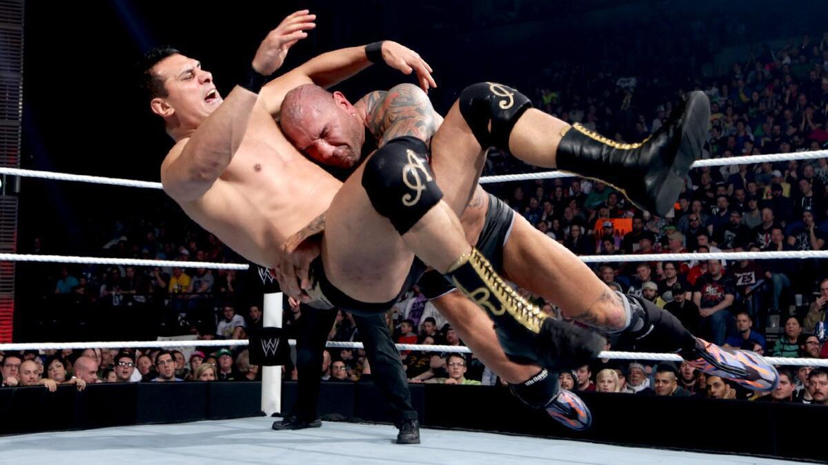 Batista spearing Alberto Del Rio in the side at WWE Elimination Chamber 2014