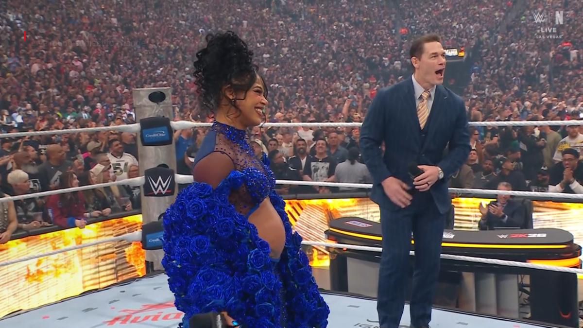 Bianca BElair with a pregnant belly alongside John Cena looking shocked