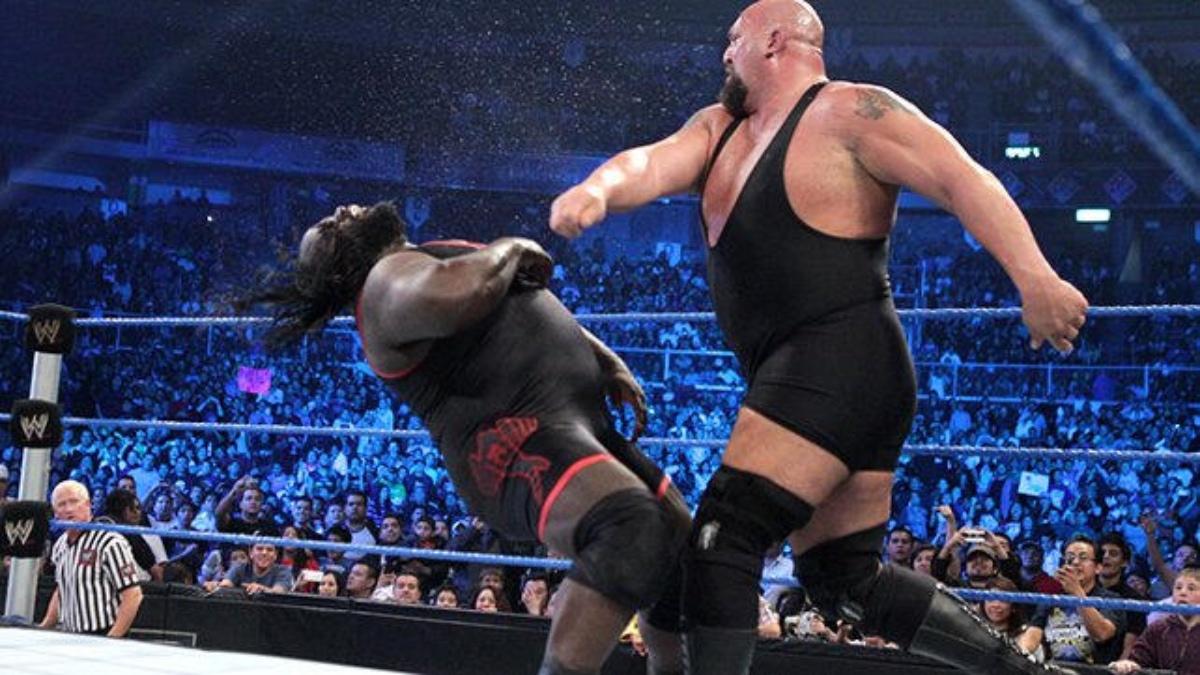 Mark Henry falling to the mat following a WMD punch from the Big Show in a WWE ring