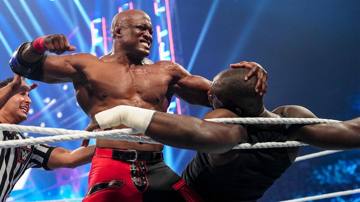 Bobby Lashley punches Omos, who is tied up in the ring ropes, during their match at WWE WrestleMania Backlash 2022