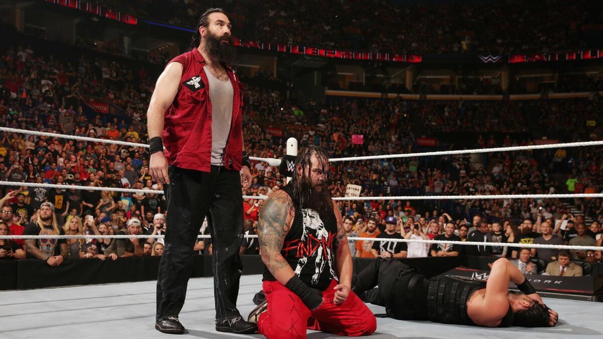 Luke Harper on his knees while Bray Wyatt stands above him at WWE Battleground 2015
