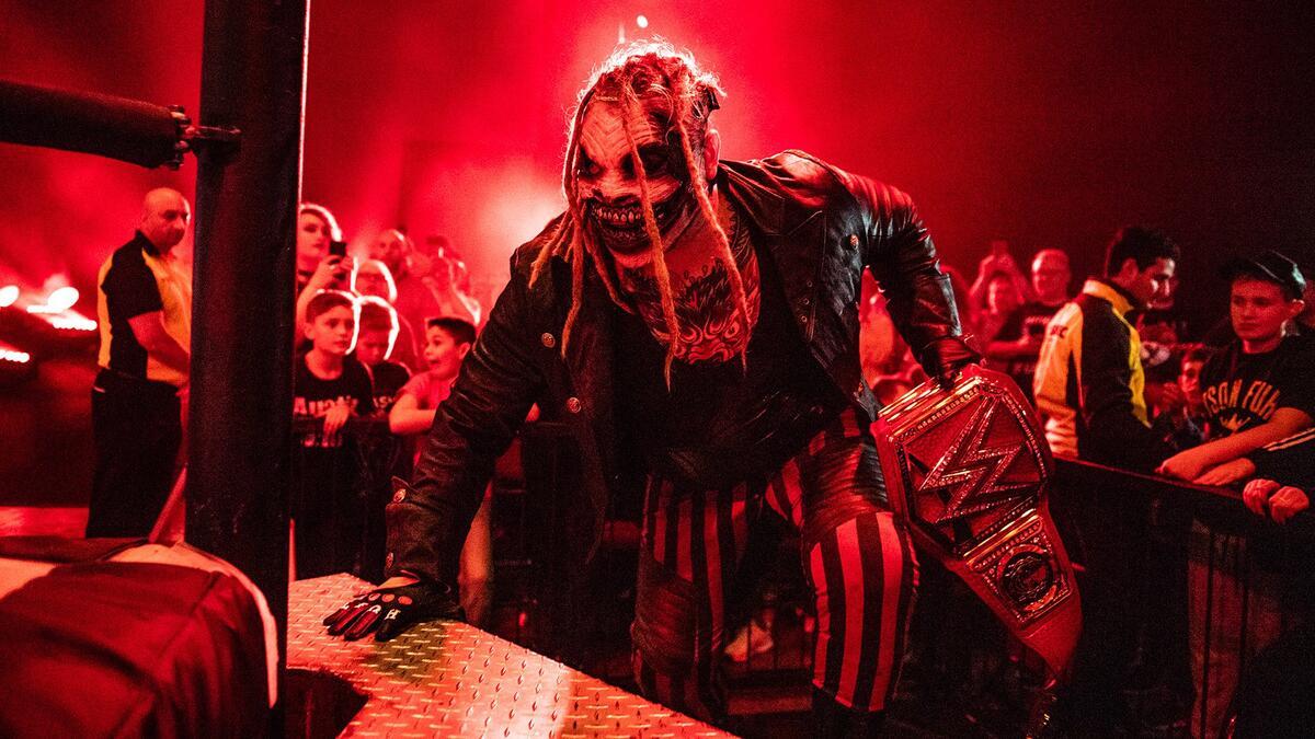 The Fiend climbing the steel steps into the ring while holding the WWE Universal Title