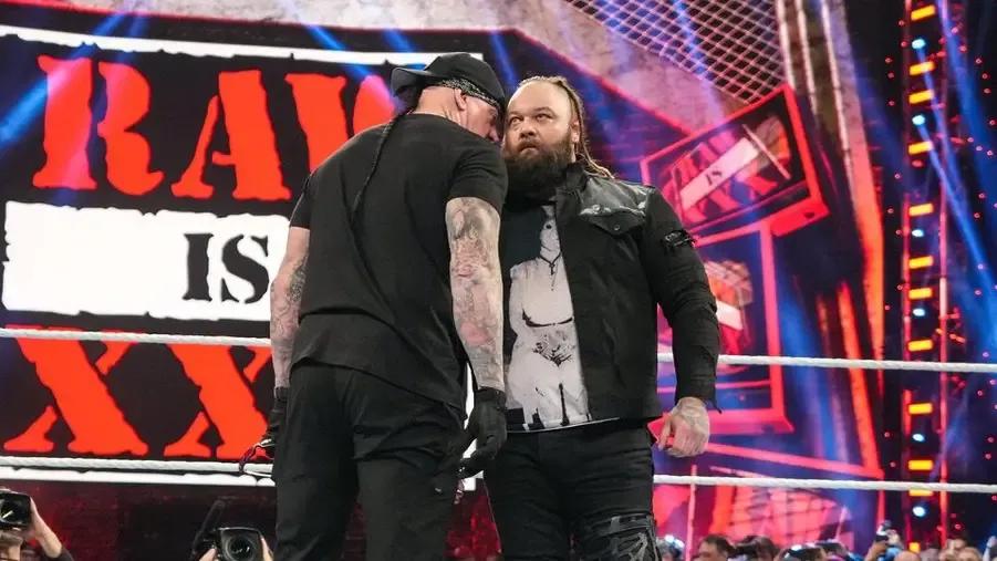 Bray Wyatt getting a whisper from Undertaker.jpg