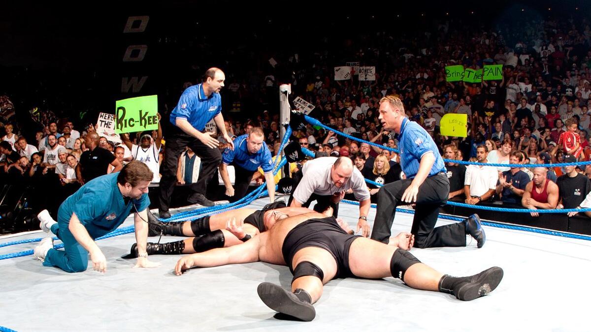 Brock Lesnar and The Big Show lay in the collapsed SmackDown ring as they are checked on by referees and Paul Heyman in 2003