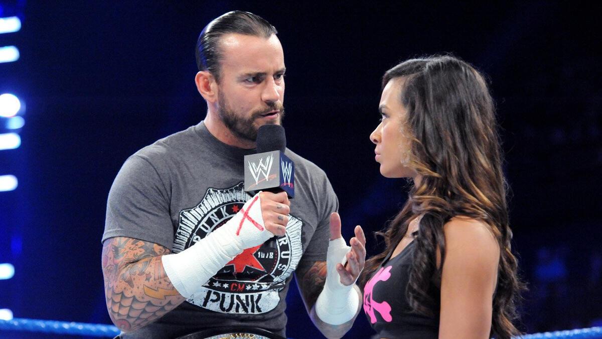 WWE Champion CM Punk speaks to AJ Lee on the microphone during a segment on SmackDown in 2012