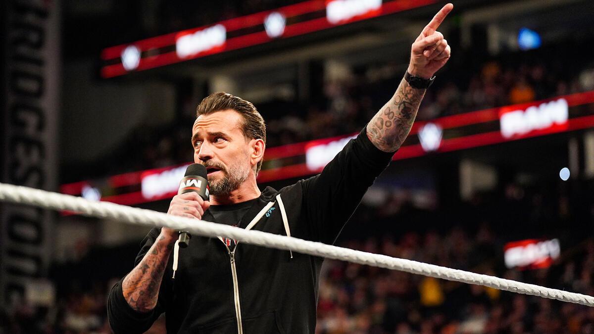 CM Punk pointing to the WWE WrestleMania 41 sign on Monday Night Raw in February 2025 while wearing a black hoodie with white pull cords