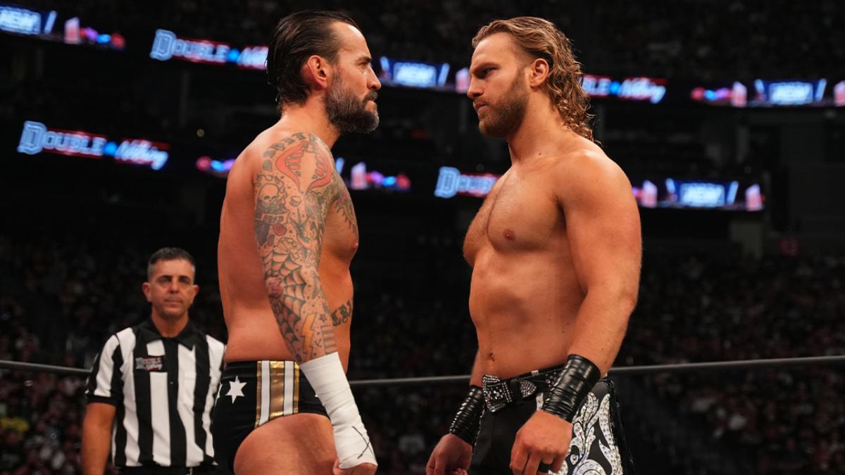 CM Punk and Hangman Page squaring off in an AEW ring as a referee watches on