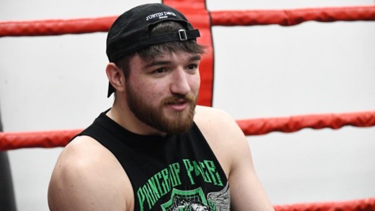 Callum Newman wearing a black vest and baseball cap on backwards