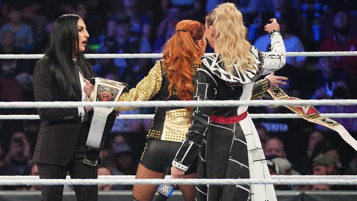 Charlotte Flair throwing the belt on the floor as Becky Lynch tries and fails to grab it 