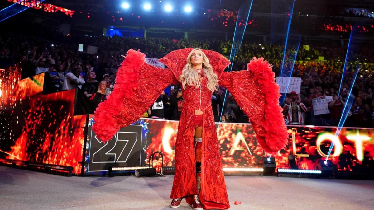 Charlotte Flair posting in a red robe, making her entrance 