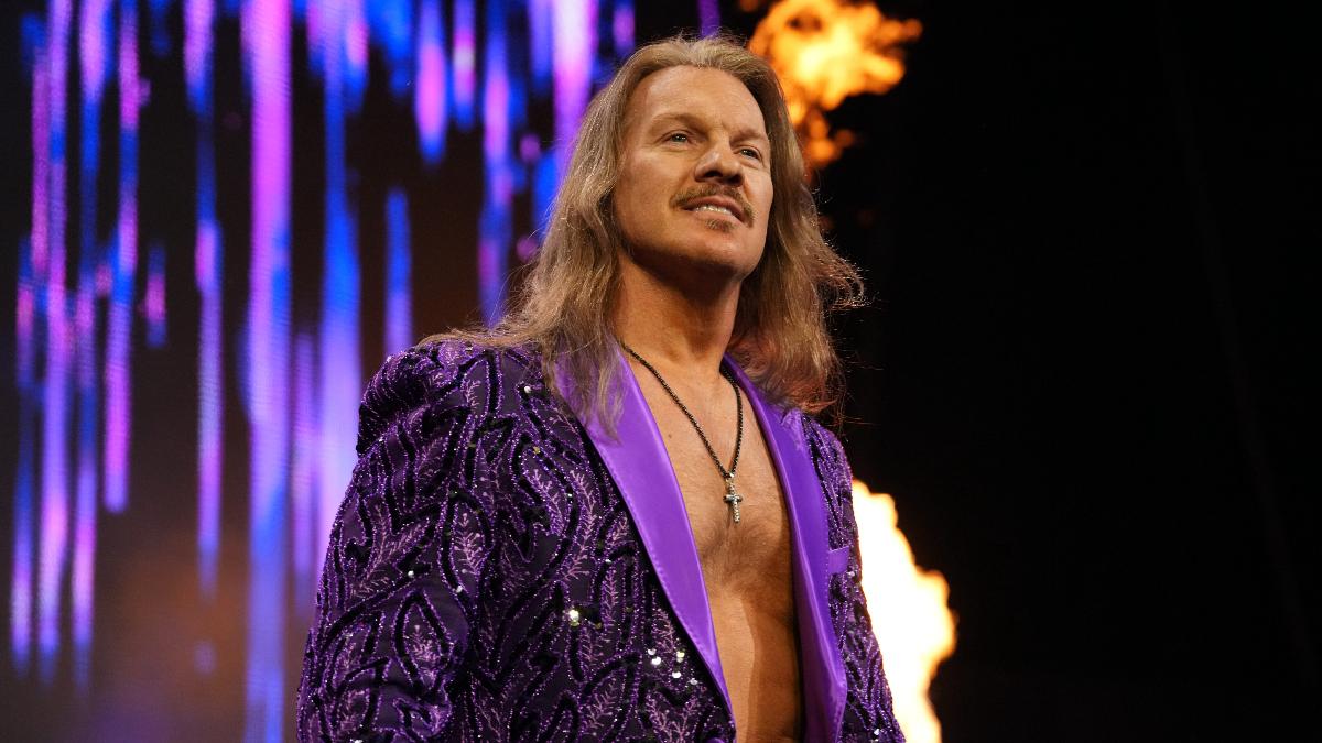 Chris Jericho, in a purple jacket, smiles off camera