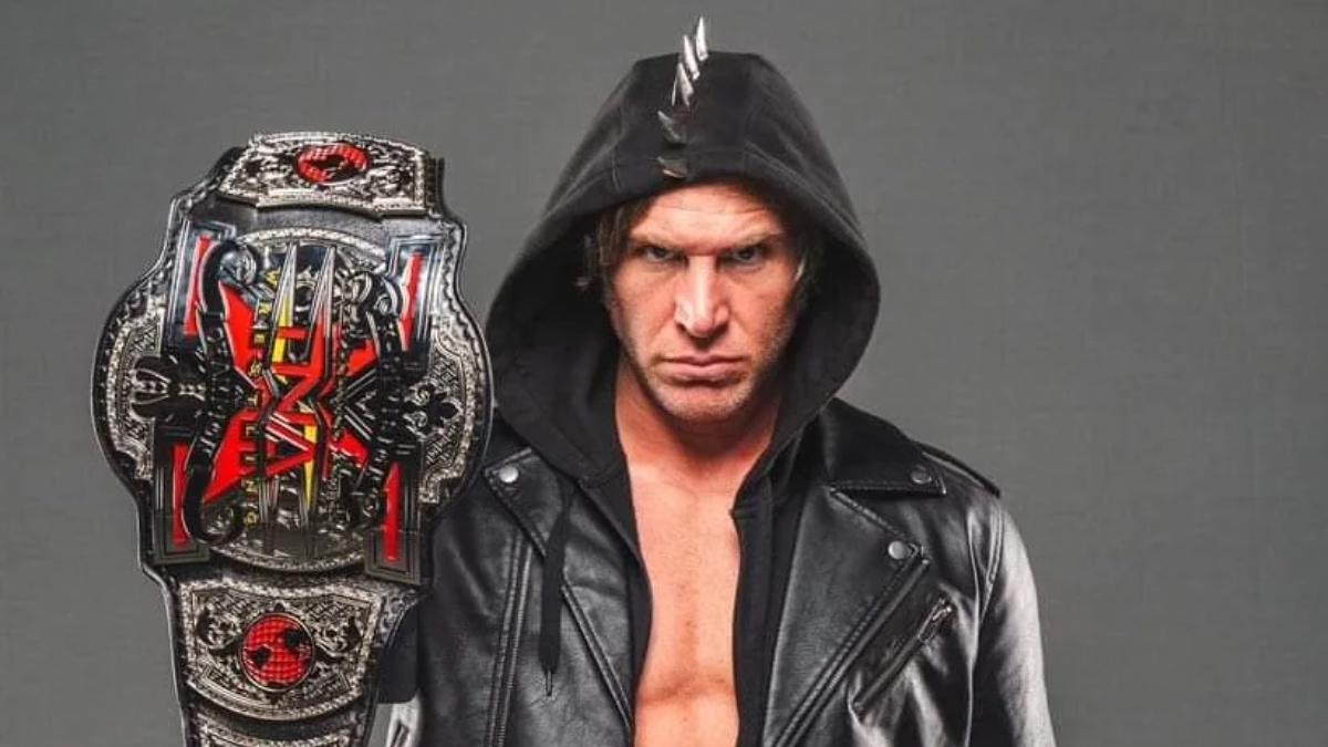 A hooded Chris Sabin holding the TNA X-Division Championship in 2024