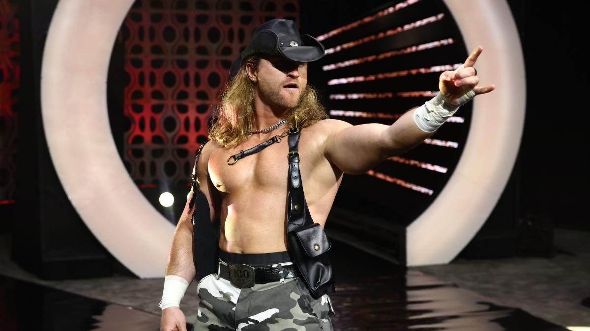 Clark Connors wearing a Crocodile Dundee hat and black vest sticking his finger out in gun pose