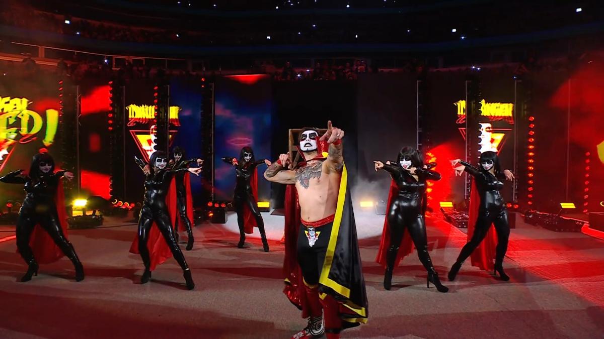 Danhausen doing his point curse as women dance behind him