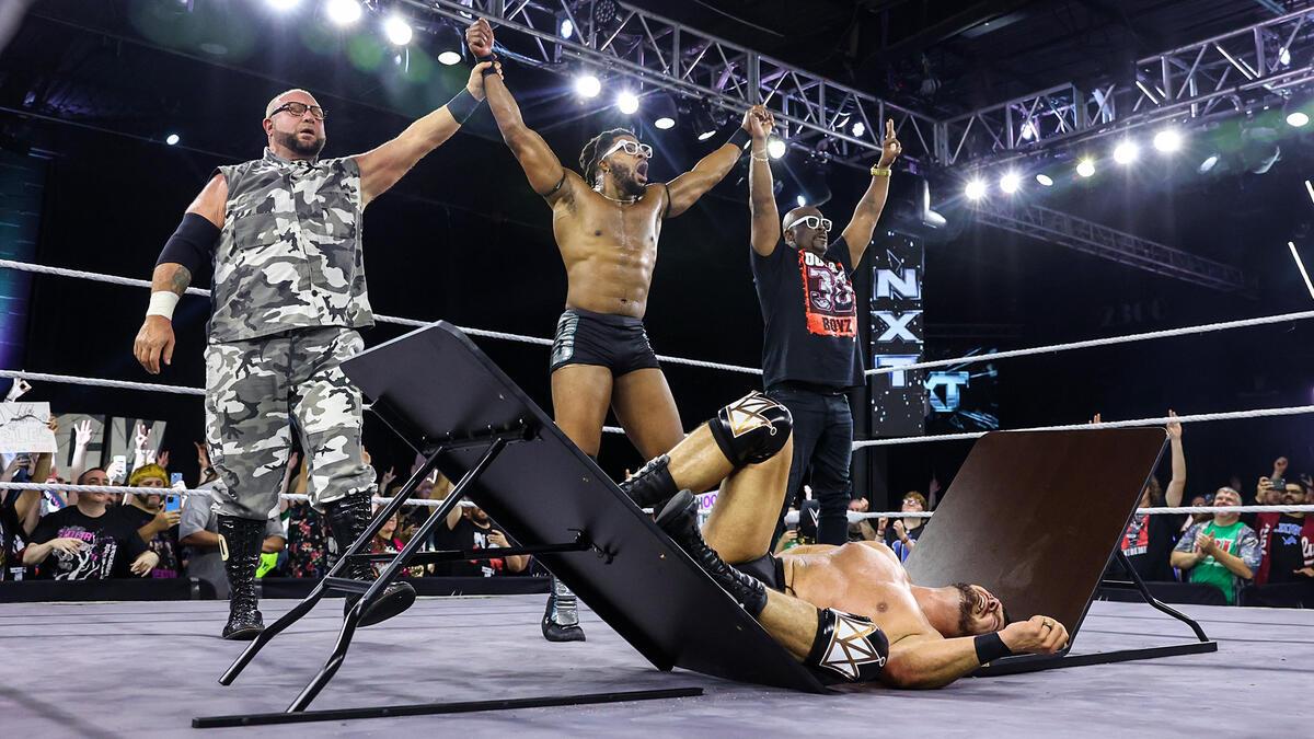 Trick Williams celebrating with The Dudley Boyz after putting Ethan Page through a table at WWE NXT 2300 