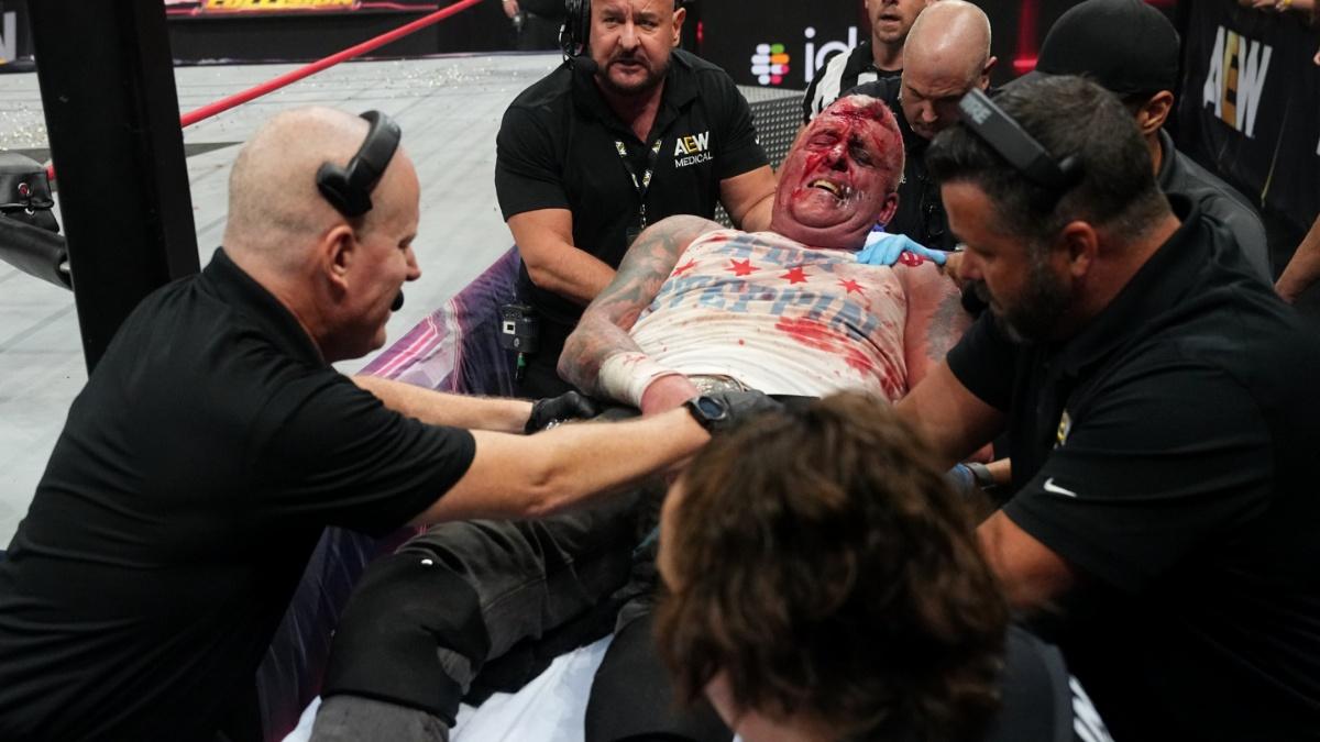 Dustin Rhodes on a stretcher and surrounded by medical staff 