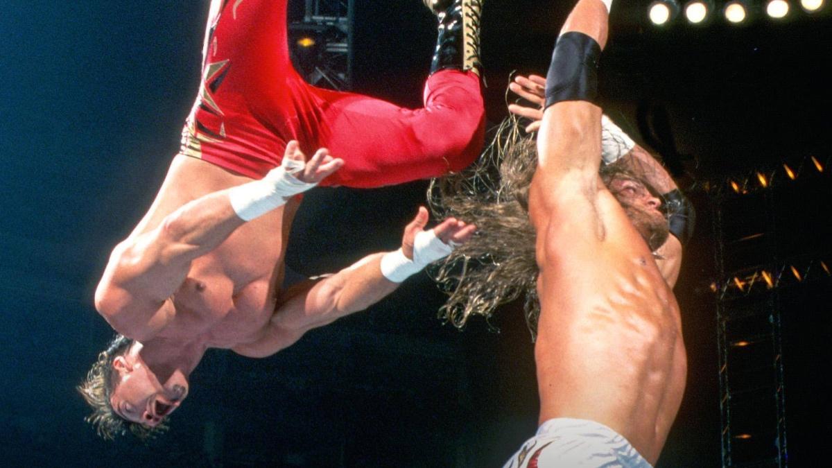 Edge after hitting Eddie Guerrero with a back body drop as Guerrero is upside down in mid-air behind him 