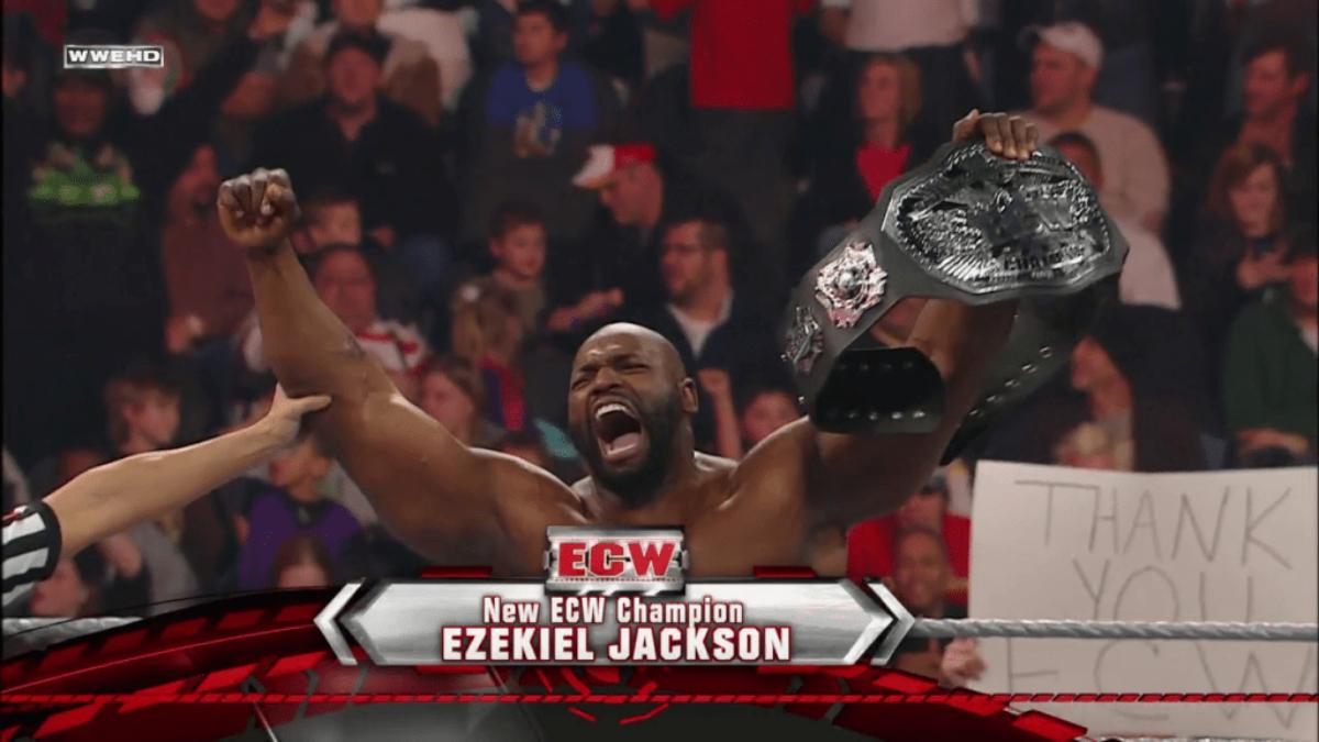 Ezekiel Jackson yelling with joy and lifting the ECW World Title belt in the air in a wrestling ring. Graphics at the bottom confirm his championship win.