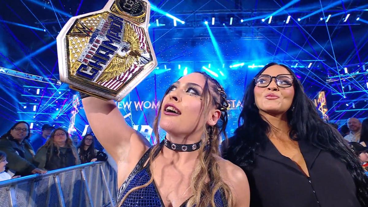 Giulia looking up at the WWE Women's United States Title as Kiana James does the same while standing slightly behind her on the SmackDown entrance ramp