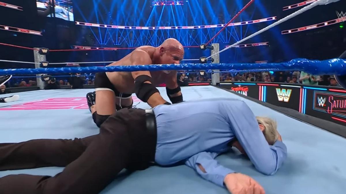 Goldberg checks on Charles Robinson after accidentally spearing the referee during his retirement match