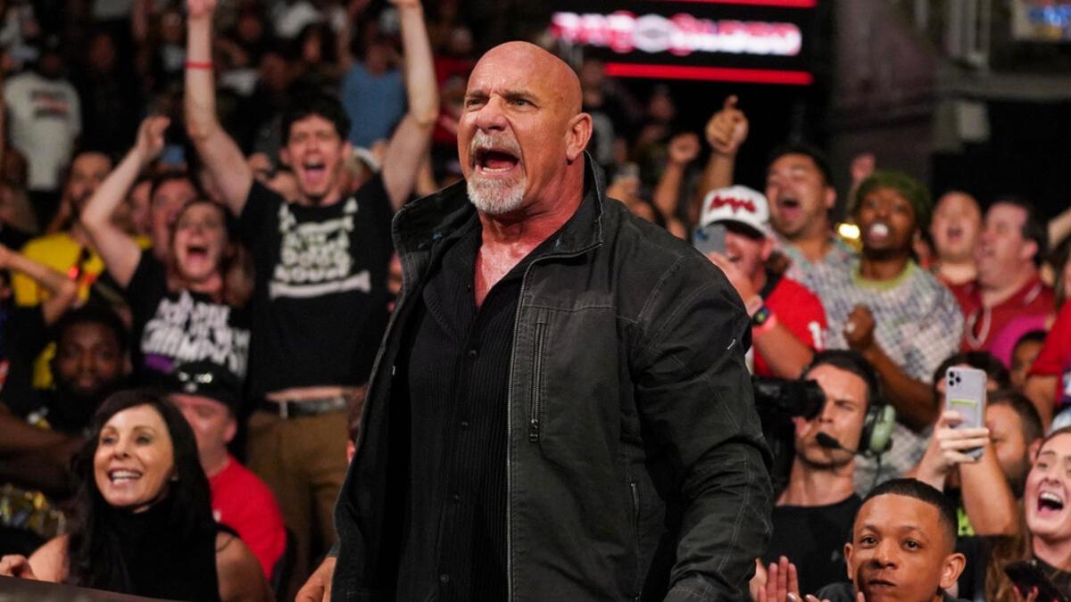 Goldberg in black shirt at Bad Blood 2024 with excited crowd in the background.