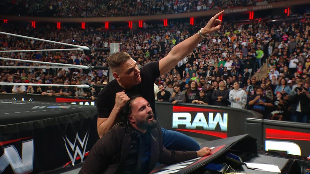 Gunther pointing at the WrestleMania 42 sign while holding Seth Rollins' head up