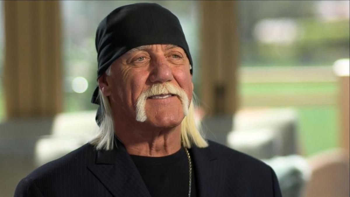 Hulk Hogan wearing all black, including a black bandana, smiling