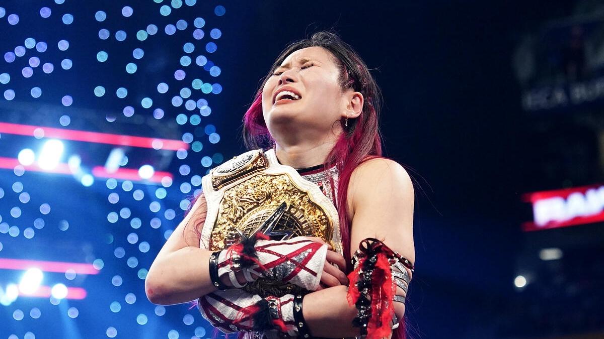 IYO SKY clutching the WWE Women's World Title