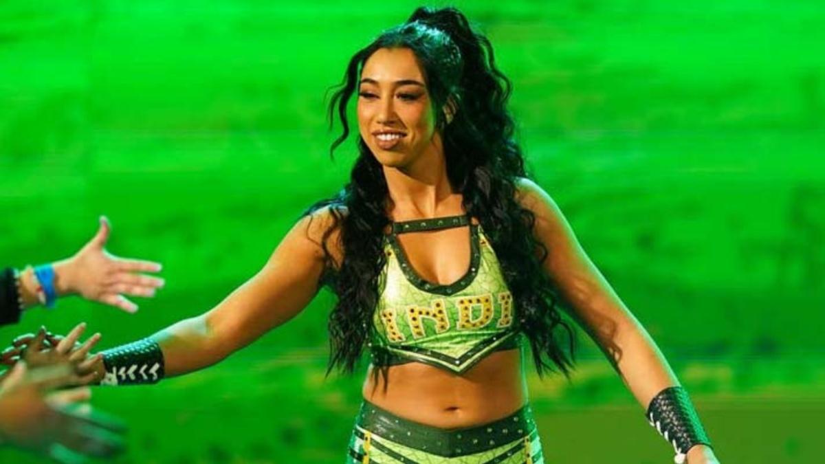 Indi Hartwell interacting with fans during her entrance, wearing green and gold attire.