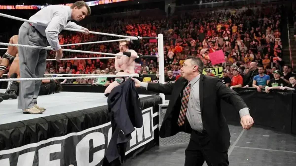 Michael Cole handing JBL his jacket at 2014 WWE Royal Rumble