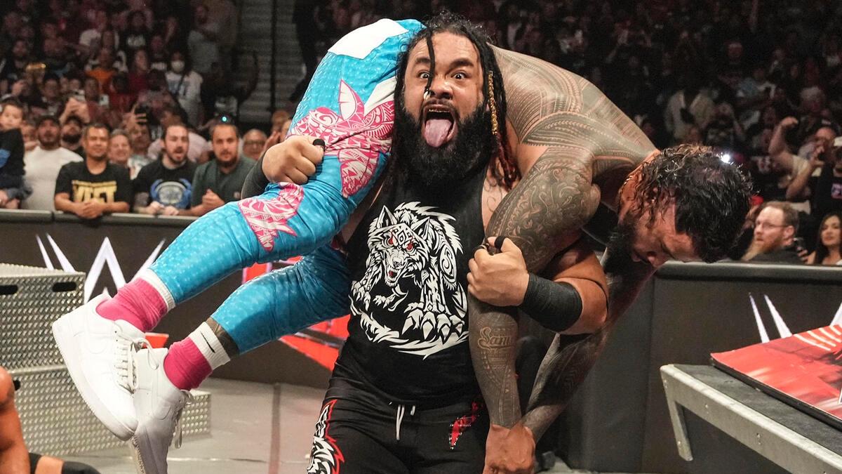 Jacob Fatu carrying Jey Uso and sticking his tongue out at ringside on WWE Raw